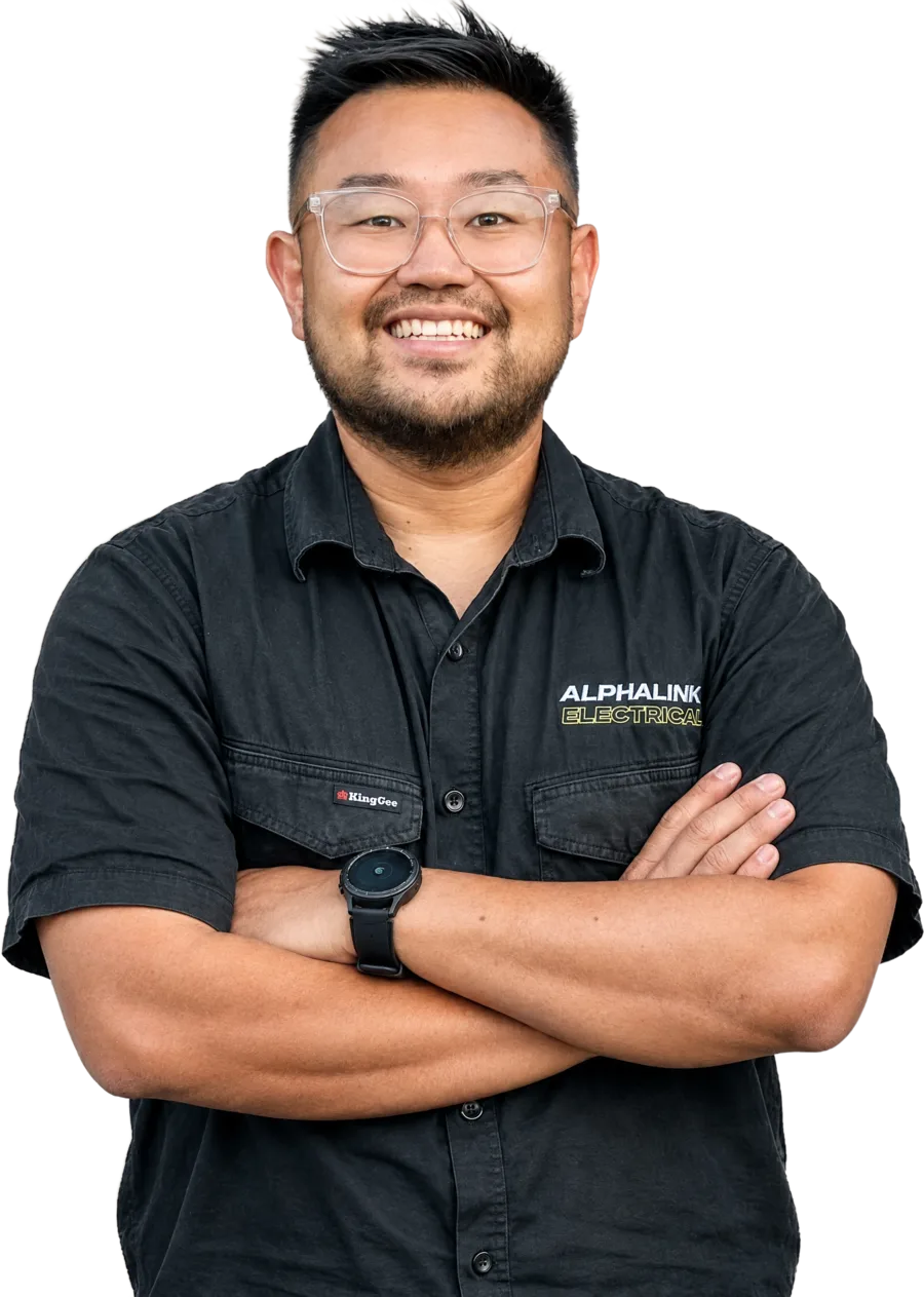 Jimmy Ly, owner of Alphalink Electrical, smiling with arms crossed