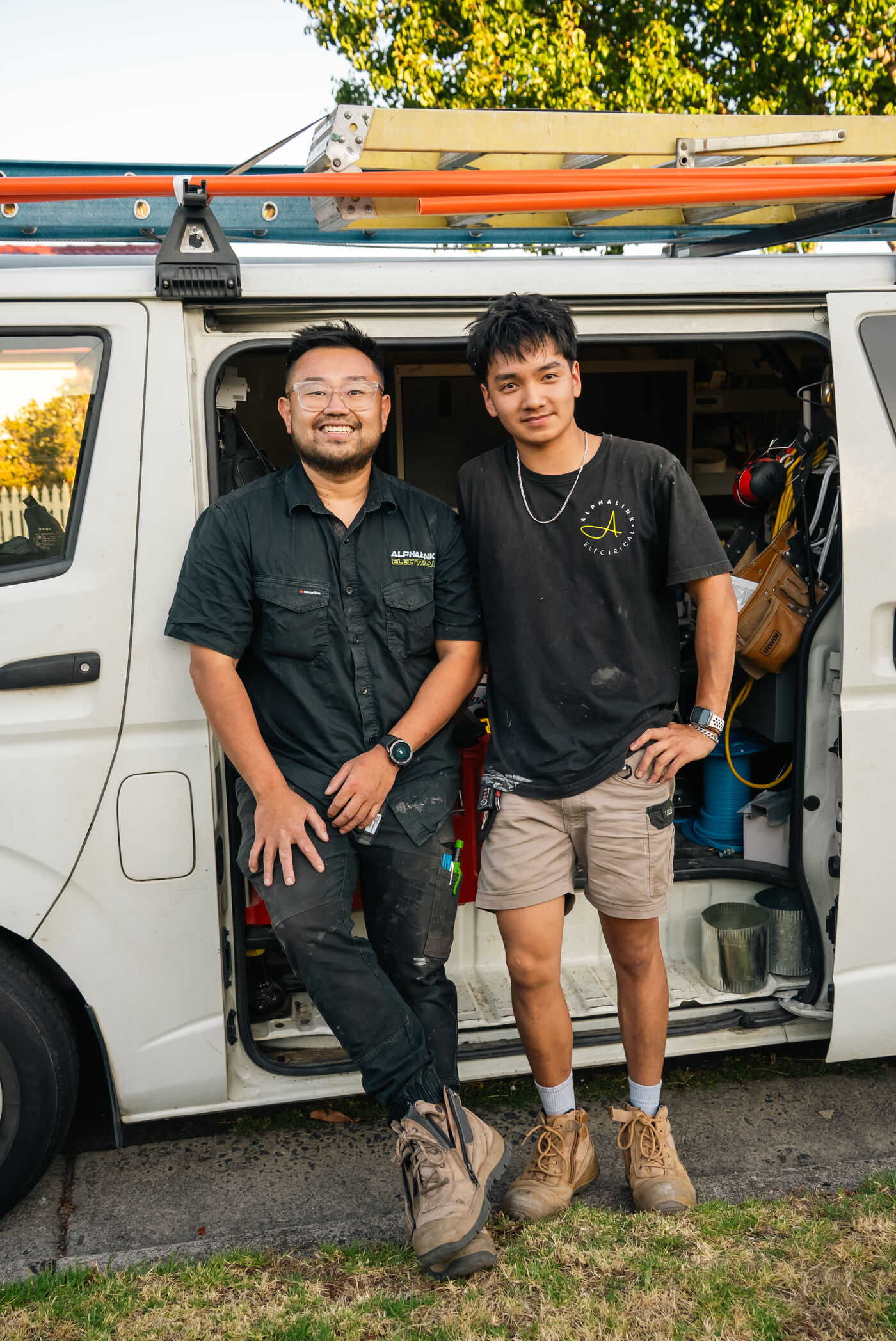 Jimmy and his apprentice smiling in front of the Alphalink work van
